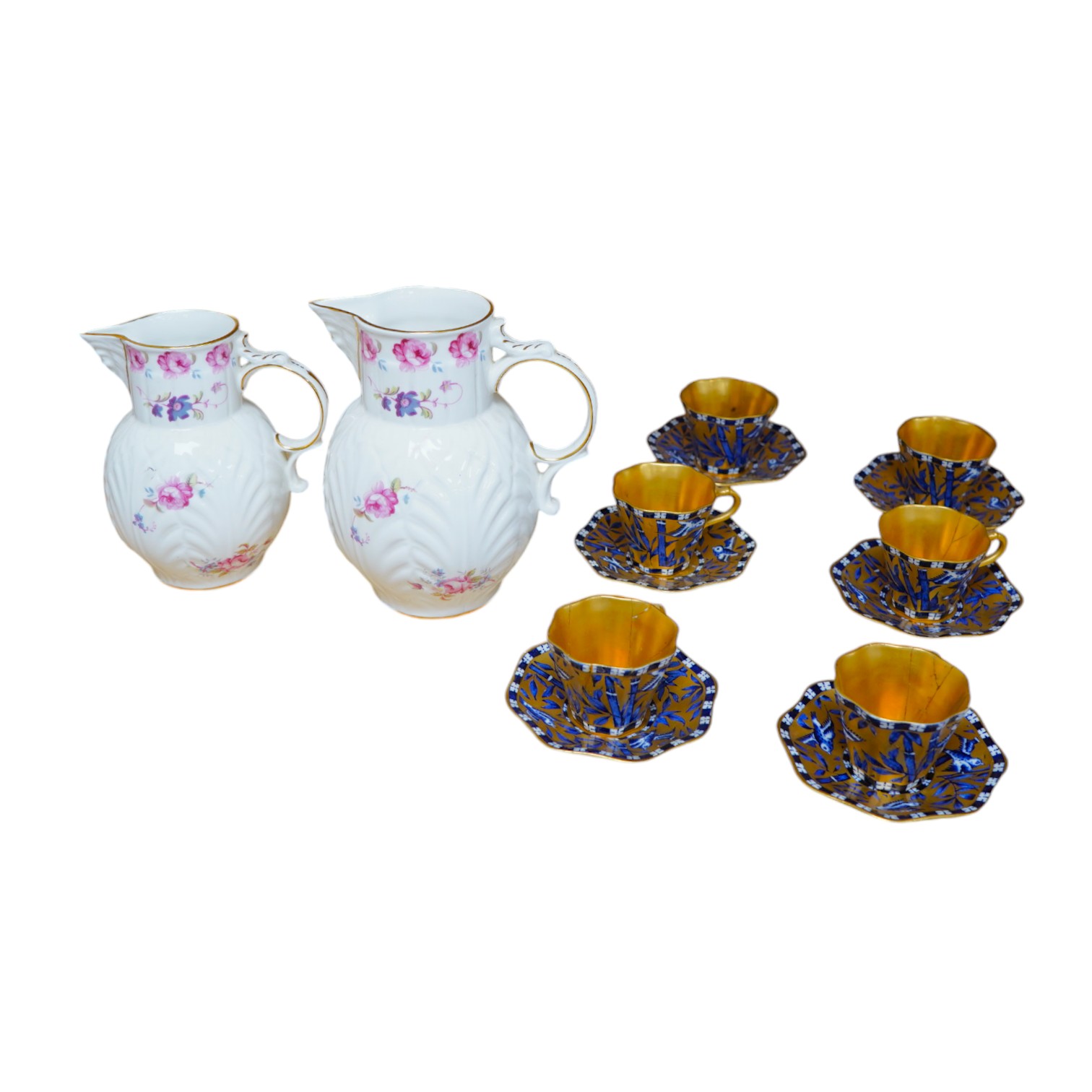 A set of six Coalport blue, gilt and white octagonal coffee cups and saucers, (three cups cracked), and two modern Coalport “Caughley Mask’’ jugs, (14), tallest 14.5cm. Condition - varies